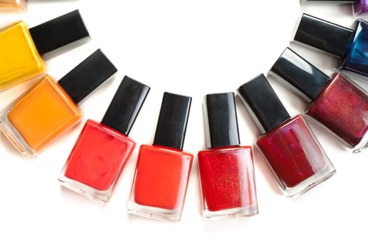 Coloured nail polish packed in a semicircle on a white background