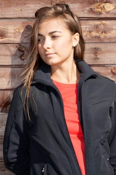 portrait of a beautiful girl on the background of the old wooden wall boards