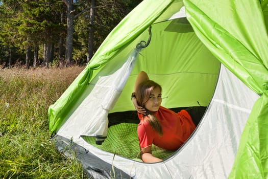 Beautiful girl in a red dress in a tent in a forest