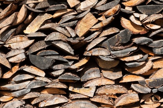 Background of dry chopped firewood logs in a pile