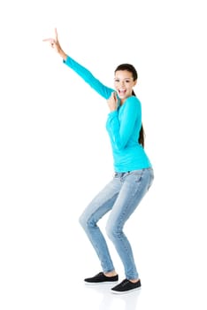 Happy , excited young woman pointing on copy space, isolated on white