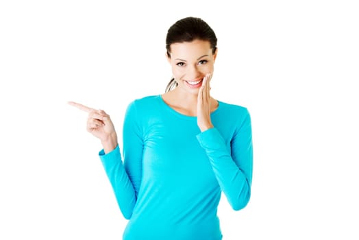 Happy , excited young woman pointing on copy space, isolated on white