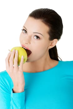 Attractive young woman eating green apple. Isolated on white background