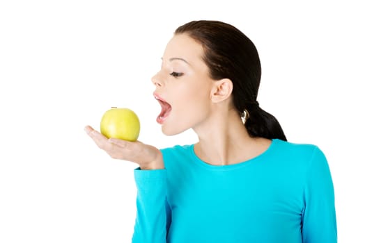 Attractive young woman eating green apple. Isolated on white background