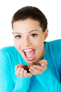 Young happy beautiful woman in casual clothes with hand full of chocolates