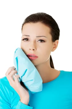 Woman pressing her bruised cheek with a painful expression as if she's having a terrible tooth ache.