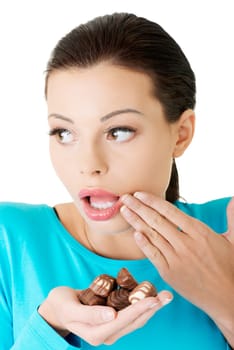 Embarrassment beautiful woman with hand full of chocolates
