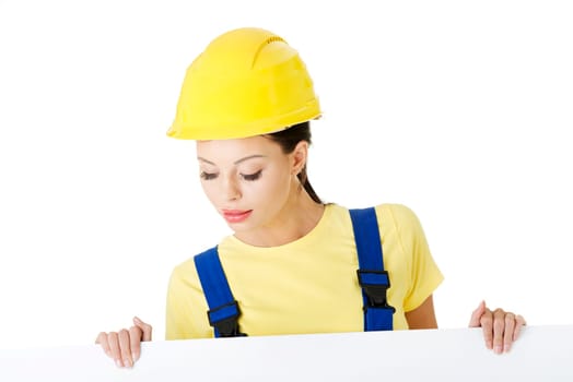 Female construction worker with blank board, isolated on white