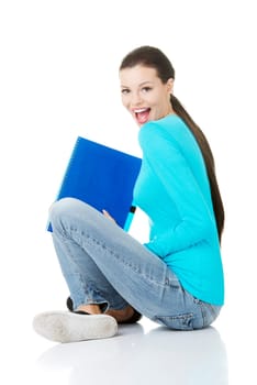 Happy student girl sitting on floor in casual clothes