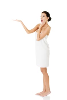 Beautiful happy woman after bath or spa, covered by white towel , showing copy space