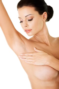 Attractive topless woman is touching her armpit with hand, isolated on white