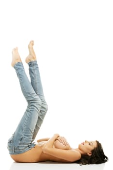 Beautiful fit sexy topless woman in blue jeans lying down, isolated on white background