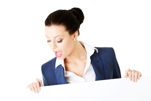 Smiling young business woman showing blank signboard, over white background isolated