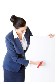 Attractive businesswoman holding blank board and writing on it with marker. Isolated on white