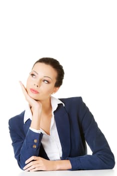 Pretty businesswoman sitting at the desk and thinking, isolated on white