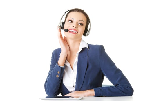 Beautiful young call-center assistant at the desk, isolated on white