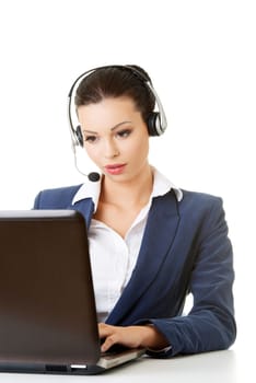 Beautiful young call-center assistant at the desk, isolated on white