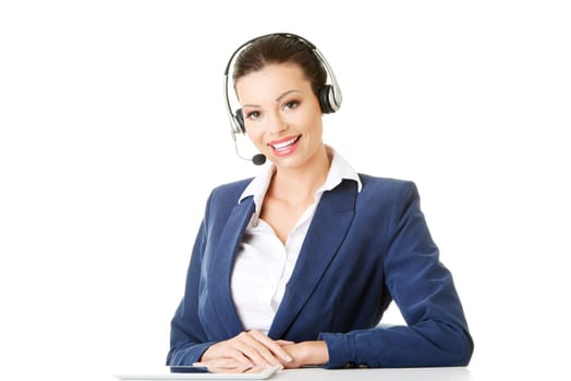 Beautiful young call-center assistant at the desk, isolated on white