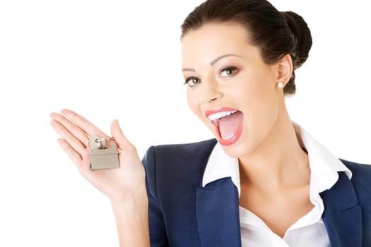 Portrait of a happy attractive caucasian businesswoman, real estate agent, holding a house key against a white background