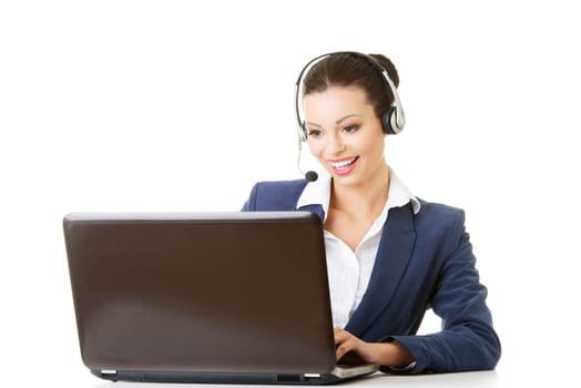 Beautiful young call-center assistant at the desk, isolated on white