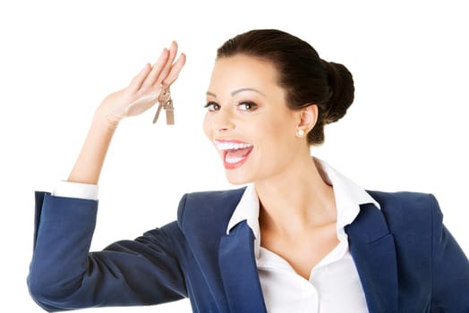 Portrait of a happy attractive caucasian businesswoman, real estate agent, holding a house key against a white background