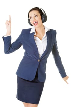 Happy attractive businesswoman listening the music through headphones