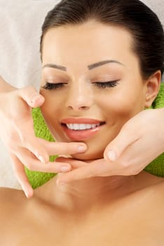 Beautiful young relaxed woman enjoy receiving face massage at spa saloon