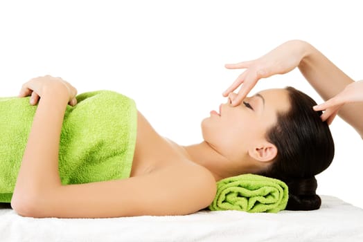 Beautiful young relaxed woman enjoy receiving face massage therapy at spa saloon