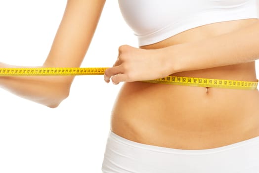 Slim fit woman in white panties with measure tape on white background