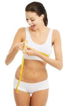 Pretty smiling woman measuring breast with measurement type - isolated on white