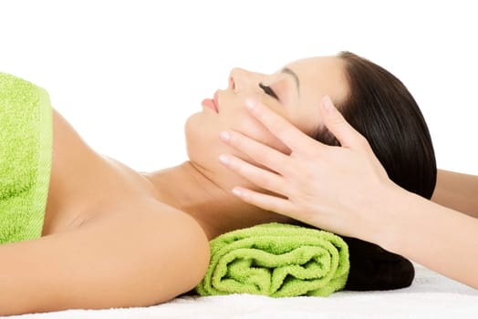Beautiful young relaxed woman enjoy receiving face massage at spa saloon