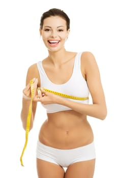 Pretty smiling woman measuring breast with measurement type - isolated on white