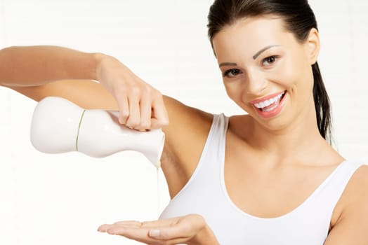 Young woman masseuse pouring olive oil from glass bottle on white background