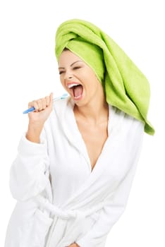 Happy attractive woman singing to tooth brush, isolated on white