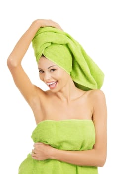 Beautiful happy woman after bath or spa, covered by green towel