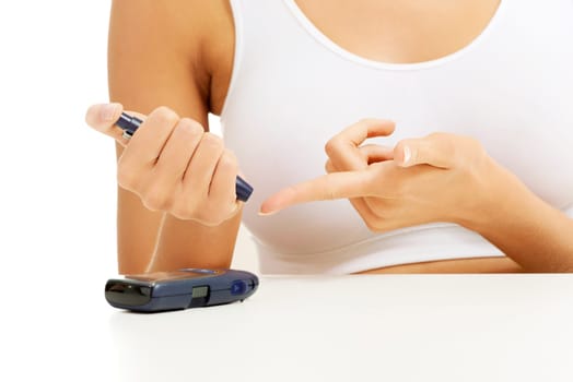 Diabetes patient measuring glucose level blood test using ultra mini glucometer and small drop of blood from finger isolated on a white background