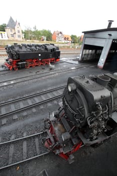 Steam locomotive in front of locomotive shed