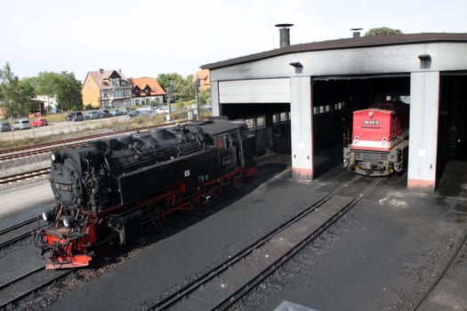 Steam locomotive in front of locomotive shed