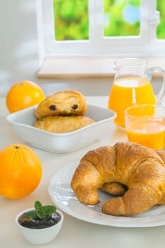 Freshly baked golden croissants served with jam and fresh orange juice for a healthy continental breakfast