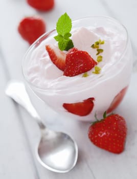 Ripe fresh strawberries with whipped cream or creamy yoghurt for a refreshing dessert