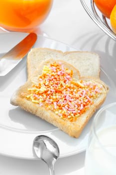 Closeup of a stylish dessert made of a slice of bread with candies and oranges
