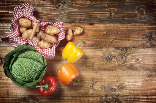 Cabbage, potatoes and peppers on wooden table