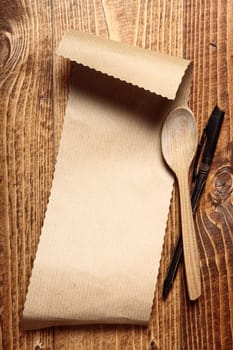Brown paper on wood with a wooden spoon and a pen
