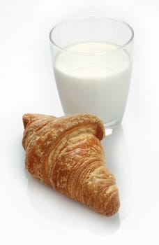 Studio shot of a glass of fresh milk and a croissant on a white background