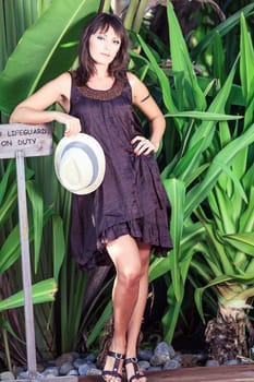 Beautiful Young woman poses in the tropical garden