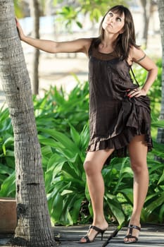 Beautiful Young woman poses in the tropical garden