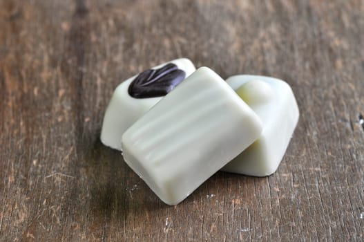 chocolate pralines on old wooden table (white chocolate)