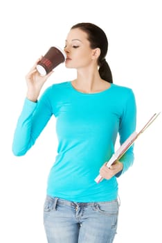 Young student or businesswoman with notebooks drinking coffee or tea from paper mug