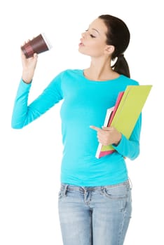 Young student or businesswoman with notebooks drinking coffee or tea from paper mug