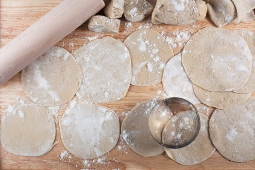 Homemade dough rolled out into circles for making potstickers.
